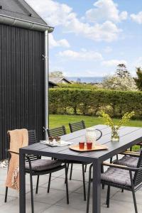 a black table and chairs on a patio at 30467-Odder-Ravnsager-15 in Odder