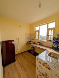a kitchen with a sink and a refrigerator in a room at Nitin Home Stay in Rewalsar