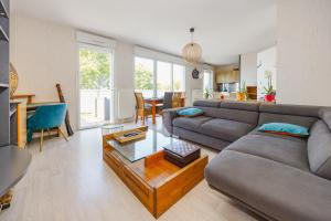 a living room with a couch and a table at An Ti Gwerned - Proche Aéroport Rennes in Saint-Jacques-de-la-Lande +7 photos