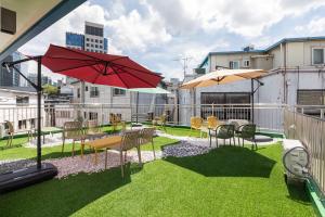 a patio with chairs and tables and umbrellas on a balcony at Hi Seodaemun in Seoul