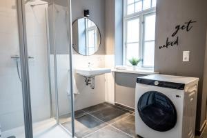 a bathroom with a shower and a washing machine at 003 - Monument - 1 bedroom - 2 beds - large living dining room in Brunsbüttel