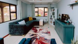 a living room with a couch and a tv at Tubungu- House of Lux& Lush in Matsapha