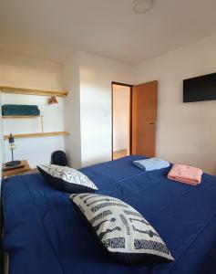 a bedroom with two beds with blue sheets and pillows at Cabaña del Mirador 1 in Puerto Pirámides