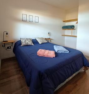 a blue bed with two towels on top of it at Cabaña del Mirador 1 in Puerto Pirámides