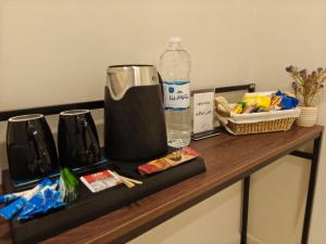 a counter with a blender and a bottle of water at Kanaf Luxury Apartment, two bedrooms and a hall in Quai