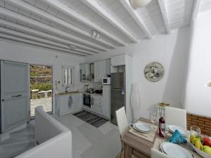 a kitchen and dining room with a table and chairs at Villa in Mykonos with Sea View and Pool in Kalafatis