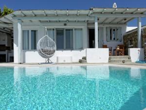 a swimming pool with a chair and a house at Villa in Mykonos with Sea View and Pool in Kalafatis +31 photos