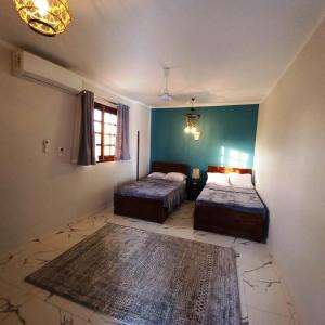 Un dormitorio con dos camas y una alfombra. en Christine Home, en Luxor