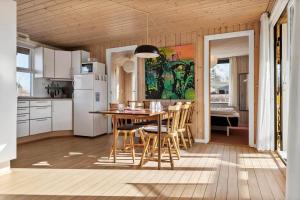 a kitchen with a table and chairs and a refrigerator at 30599-Odder-Strandagervej-1 in Odder
