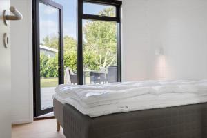 une chambre avec un lit et une grande fenêtre dans l'établissement 30315-Odder-Grindevej-22, à Odder
