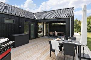 une cuisine extérieure et un coin repas avec une terrasse dans l'établissement 30315-Odder-Grindevej-22, à Odder