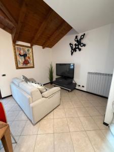 a living room with a couch and a flat screen tv at Black and White in Locate Bergamasco