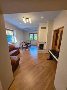 Una sala de estar con un sofá y un piano. en Coastal Luxe Retreat, en Jūrmala