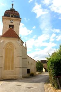 a church with a tower with a clock on it at Appartement Hibou in Pesmes