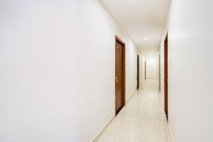 einen leeren Flur mit weißen Wänden und weißen Fliesenböden in der Unterkunft Hotel O Skyline in Surūrnagar