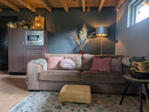 a living room with a brown couch and a table at Appartement Het Gewei in Rotsterhaule