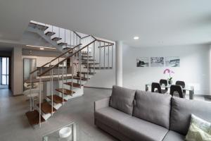 a living room with a couch and a spiral staircase at Apartamentos Cordial Mogán Paraíso in Puerto de Mogán