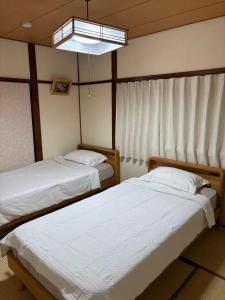 Postel nebo postele na pokoji v ubytování Hane羽の宿