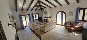 カシオピにあるThe Little Olive Press, Kassiopiのソファと暖炉のある広いリビングルーム