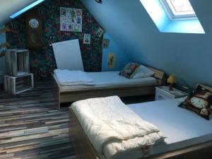 a attic bedroom with two beds and a window at Perle de sel, centre du Crotoy, 8 pers in Le Crotoy