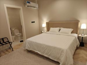 a bedroom with a large white bed and a bathroom at Kanaf Luxury Apartment, two bedrooms and a hall in Quai