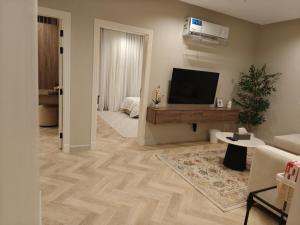 a living room with a flat screen tv on the wall at Kanaf Luxury Apartment, two bedrooms and a hall in Quai