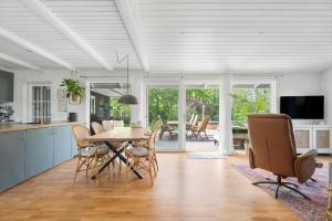 a kitchen and dining room with a table and chairs at 30338-Odder-Skovlunden-11 in Odder