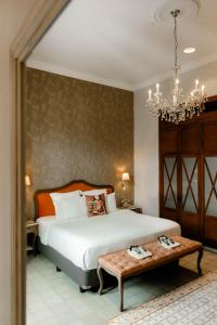 une chambre avec un lit avec une table et un lustre dans l'établissement La Concordia - Boutique Hotel, à Panama City 90 autres photos