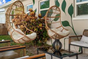 two wicker chairs on a table in front of a house at The Beverley Pool Hot Tub Near Clearwater Beach in Clearwater