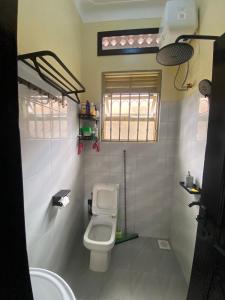 a small bathroom with a toilet and a sink at Bright and Spacious Apartment Perfect Location in Wakiso