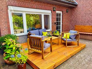 a wooden deck with two chairs and a table at Zwischen Wolfsburg, Tankumsee und Ilkerbruch - Apartment im Boldecker Land in Osloß