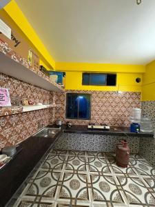 a kitchen with a tile floor and yellow cabinets at Cozy Nest in Guwahati