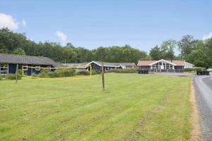 Un campo de hierba al lado de una casa y una carretera. en 40567-Juelsminde-Pot-Strandby-370, en Sønderby