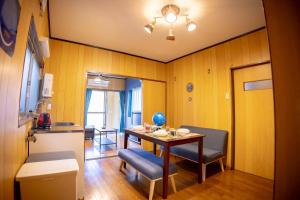 ein Zimmer mit Tisch und Stühlen und eine Küche in der Unterkunft Voyager Inn in Tokio
