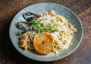 a blue bowl of food with noodles and vegetables at The Catalyst Apartment Hotel by NEWMARK in Johannesburg