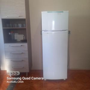 a white refrigerator in the corner of a room at Alojamento para Empreiteira in Sumaré