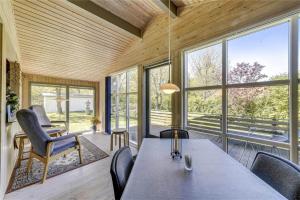 a dining room with a table and chairs and windows at 30312-Odder-Lyngbakkevej-29 in Odder +25 photos
