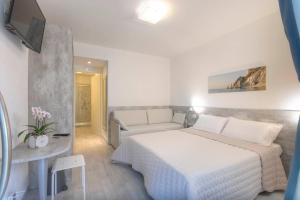 a bedroom with a white bed and a couch at Affittacamere da Sabri in Numana