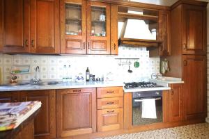 a kitchen with wooden cabinets and a stove at Villa La Meridiana in Luciana +11 photos