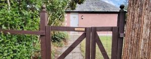un cancello in legno di fronte a un edificio di Gorton House & Orchard Cottages a Roslin