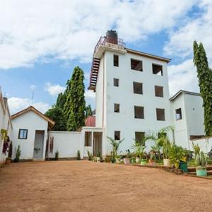 a large white building with trees in front of it at Kilimanjaro Budget Lodge in Msaranga