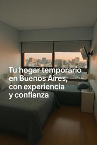 a bedroom with a bed and a window with a city at Tango BA 2 in Buenos Aires