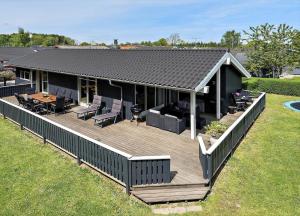una casa con una gran terraza de madera en un patio en 40508-Juelsminde-Pot-Strandby-344, en Sønderby
