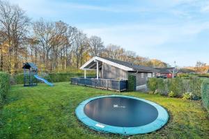 una pequeña piscina en un patio con parque infantil en 40508-Juelsminde-Pot-Strandby-344, en Sønderby