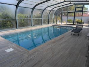 a swimming pool in a greenhouse with a large swimming pool at Stay Padel House in Perpignan