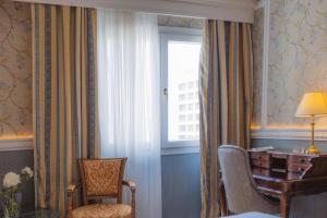 Habitación con escritorio, silla y ventana. en Mediterranean Palace, en Tesalónica