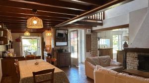 a kitchen and living room with a table and a couch at La Jarisse in Saint-Martin-de-Fressengeas