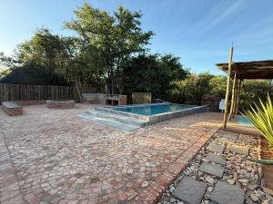 a patio with a swimming pool on top of a brick yard at Moyo Safari Lodge in Alldays