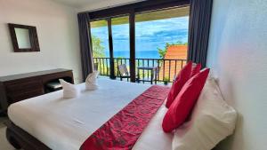 Un dormitorio con una cama con almohadas rojas y un balcón. en SeaView Villa Tropicana, en Salad Beach