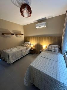 a bedroom with two beds and a ceiling at Apartamento Luxo em Japaratinga in Japaratinga +16 photos